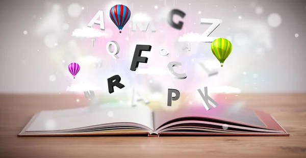 Open book with flying 3d letters on concrete background — Stock Photo, Image