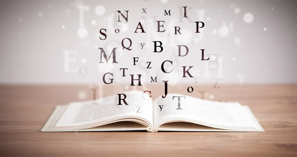 Livre ouvert avec lettres volantes — Photo