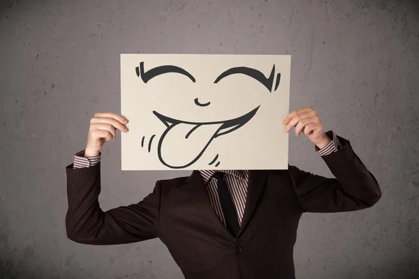 Empresário segurando um papel com cara sorridente engraçado na frente de h — Fotografia de Stock