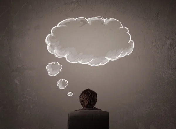Byznysmen sedí s mraky myšlenek nad hlavou — Stock fotografie