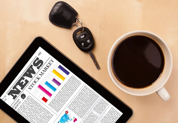 Tablet pc shows news on screen with a cup of coffee on a desk — Stock Photo, Image