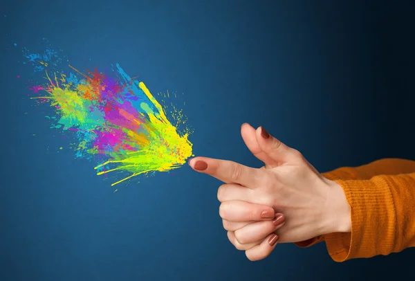 Colorful splashes are coming out of gun shaped hands — Stock Photo, Image