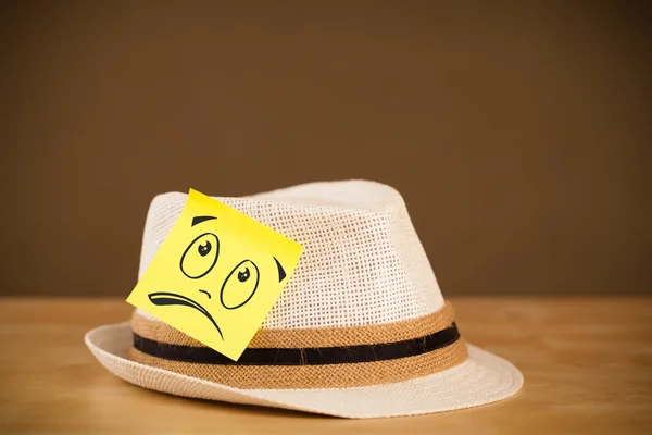 Nota post-it con la cara sonriente pegada en el sombrero —  Fotos de Stock