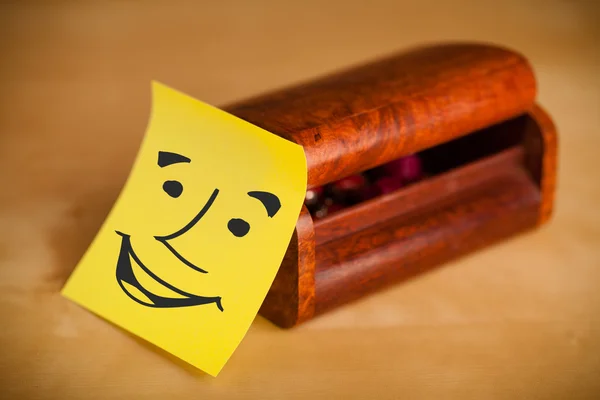 Nota post-it con la cara sonriente pegada en una caja — Foto de Stock