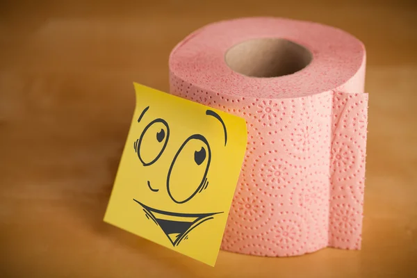 Post-it note with smiley face sticked on toilet paper — Stock Photo, Image