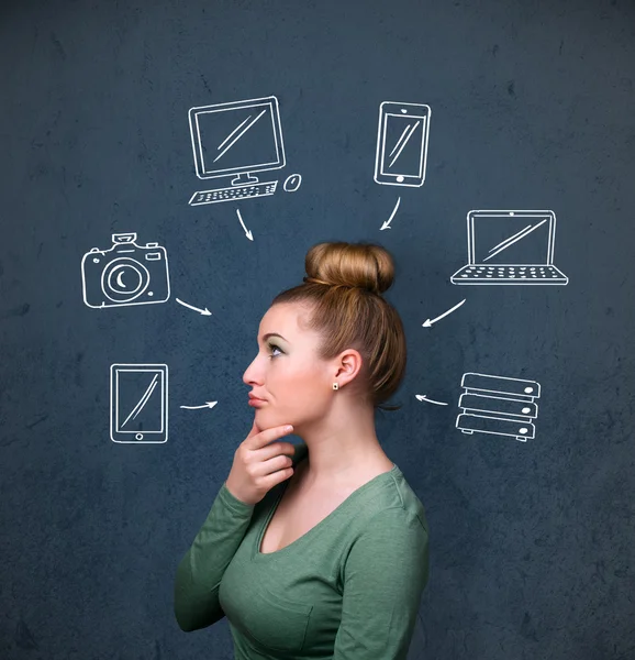 Jovem mulher pensando com gadgets desenhados em torno de sua cabeça — Fotografia de Stock