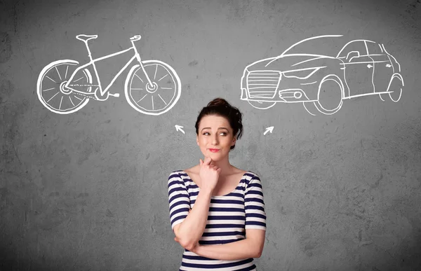 Mulher fazendo uma escolha entre bicicleta e carro — Fotografia de Stock