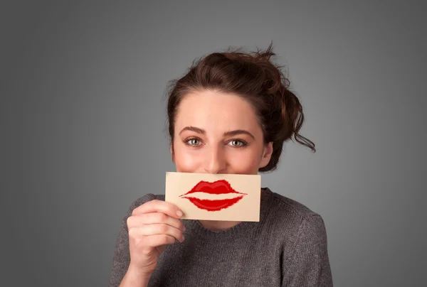 Feliz mulher bonita segurando cartão com marca batom beijo — Fotografia de Stock