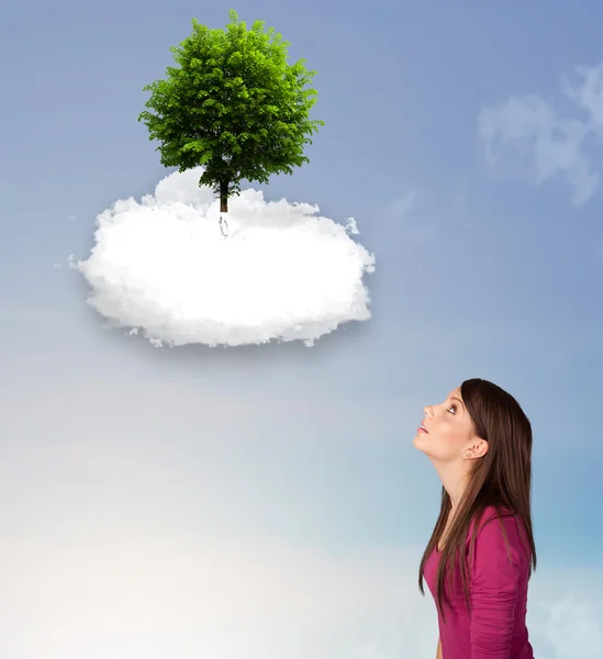 Niña apuntando a un árbol verde en la parte superior de una nube blanca — Foto de Stock