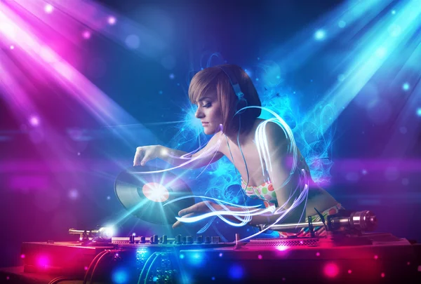 Energetic Dj girl mixing music with powerful light effects — Stock Photo, Image