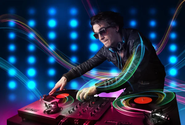 Jovem Dj misturando registros com luzes coloridas — Fotografia de Stock