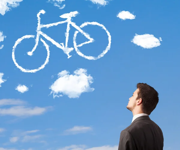 Jongeman kijkt naar fietsenwolken aan de blauwe hemel — Stockfoto