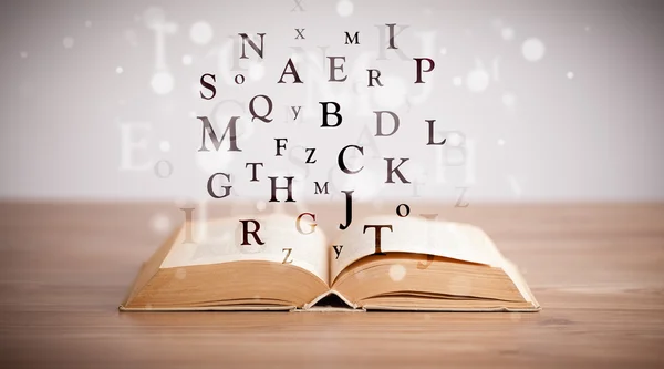 Opened book with flying letters — Stock Photo, Image