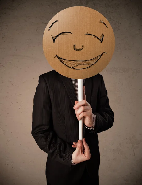 Empresário segurando um smiley face board — Fotografia de Stock