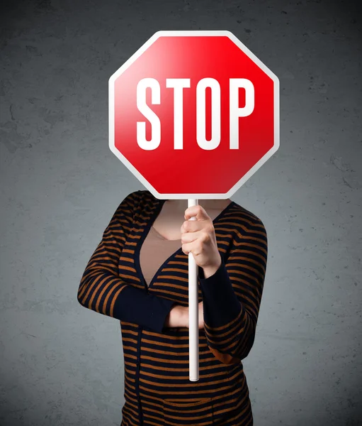 Mujer joven sosteniendo una señal de stop — Foto de Stock
