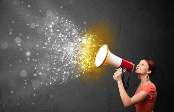 Woman shouting into megaphone and glowing energy particles explo — Stock Photo, Image