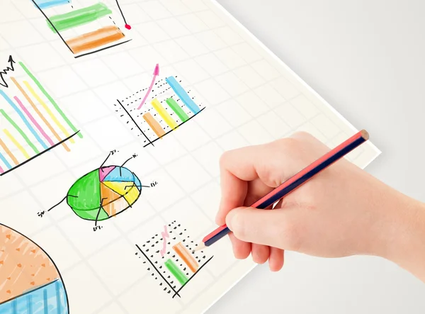 Persona de negocios dibujo coloridos gráficos e iconos en papel —  Fotos de Stock