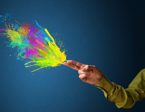 Salpicaduras de colores están saliendo de las manos en forma de pistola —  Fotos de Stock