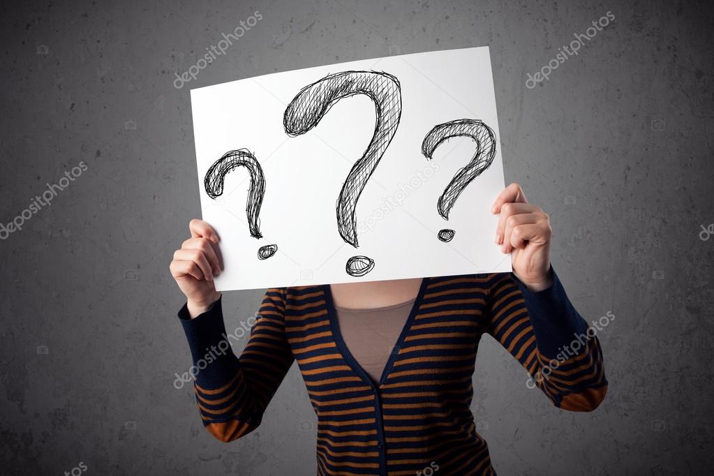 Woman holding paper with drawed question marks in front of her h