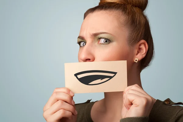 Pretty young girl holding white card with smile drawing — Stock Photo, Image