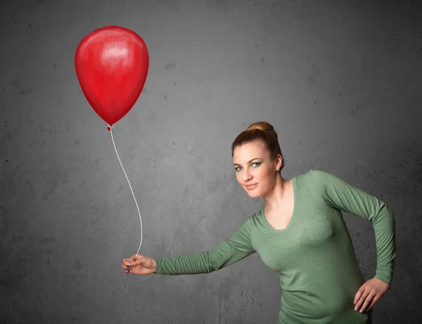 Femme tenant un ballon rouge — Photo