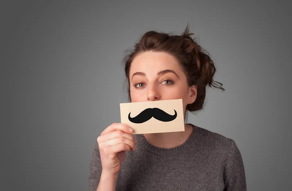 Feliz linda chica sosteniendo papel con bigote dibujo —  Fotos de Stock