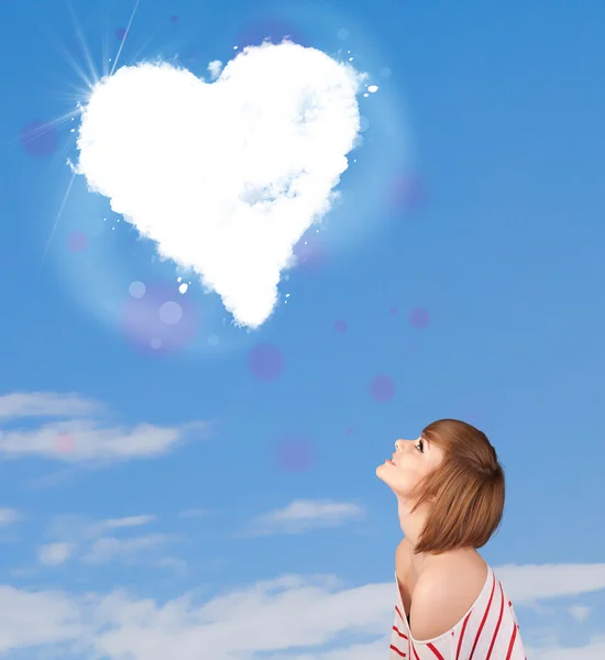 Niedliches Mädchen schaut auf weiße Herzwolken am blauen Himmel — Stockfoto