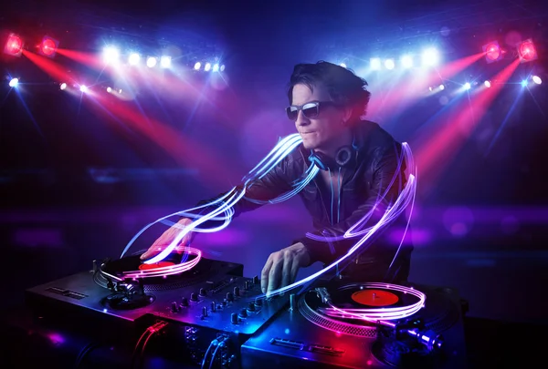 Disc jockey playing music with light beam effects on stage — Stock Photo, Image