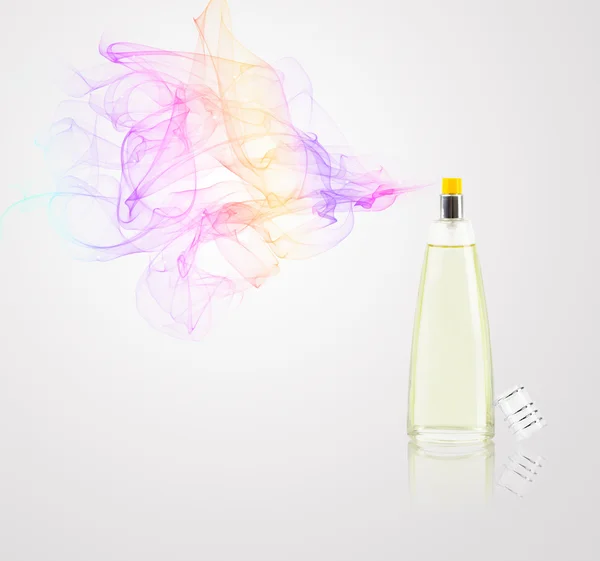 Perfume bottle spraying colored scent — Stock Photo, Image