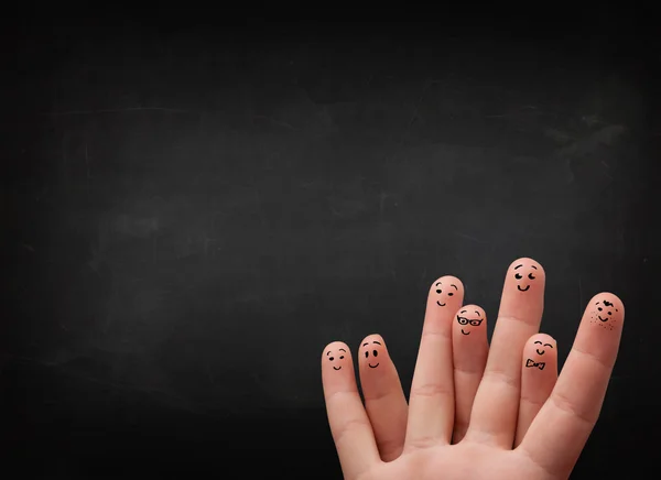 Happy smiley fingers looking at empty black chalboard — Stock Photo, Image