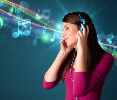Kulaklıkla müzik dinleyen genç bir kadın.