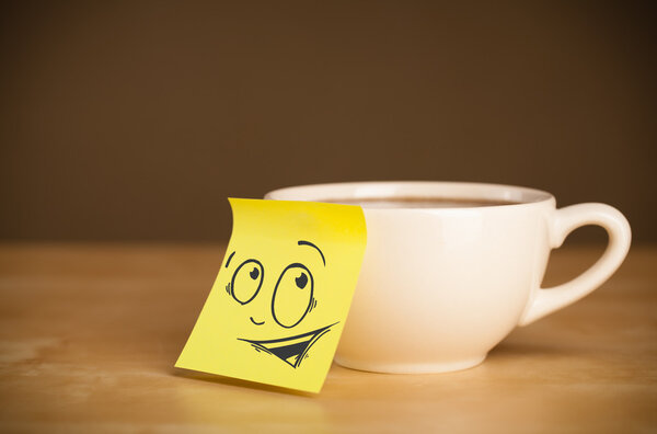 Post-it note with smiley face sticked on cup