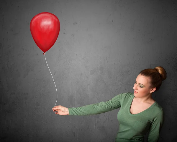 Donna che tiene un palloncino rosso — Foto Stock