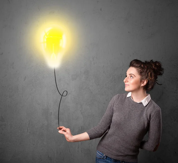 Woman holding a lightbulb balloon — Stock Photo, Image