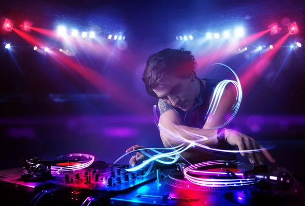 Discjockey som spelar musik med ljusstrålen effekter på scenen — Stockfoto