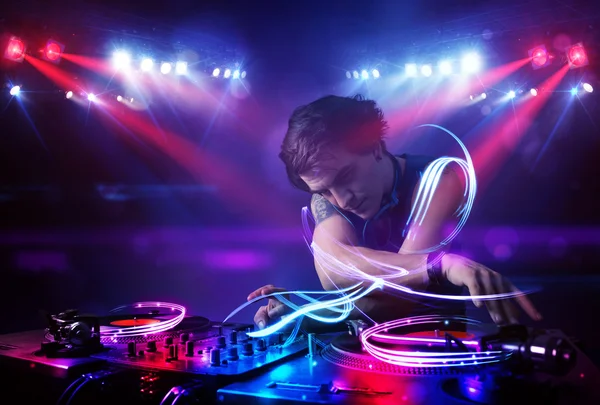 Disc jockey playing music with light beam effects on stage — Stock Photo, Image