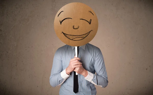 Affärsman som innehar en smiley face styrelse — Stockfoto