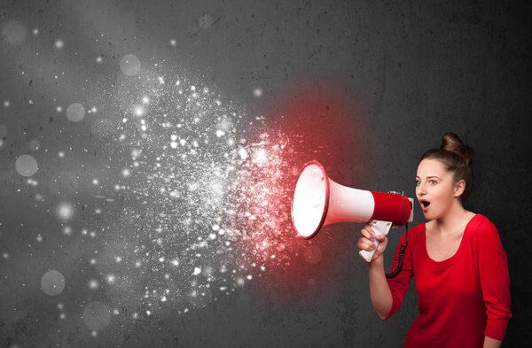 Женщина кричит в мегафон и исследует светящиеся частицы энергии
