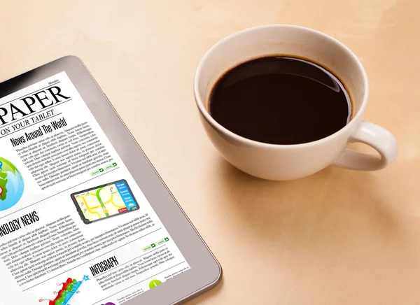 Tablet PC muestra noticias en pantalla con una taza de café en un escritorio —  Fotos de Stock