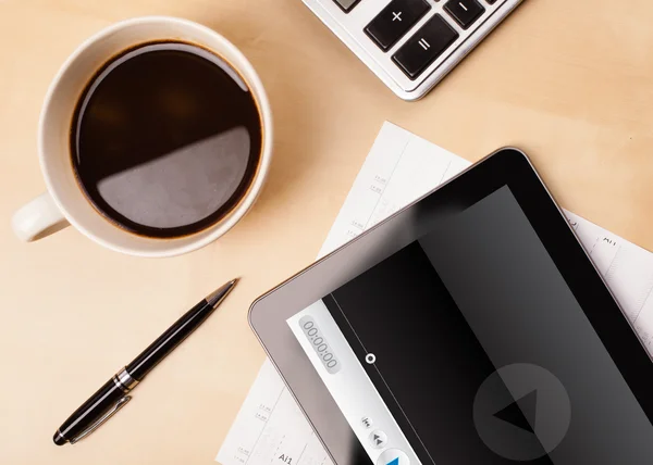 Tablet pc showing media player on screen with a cup of coffee on — Stock Photo, Image