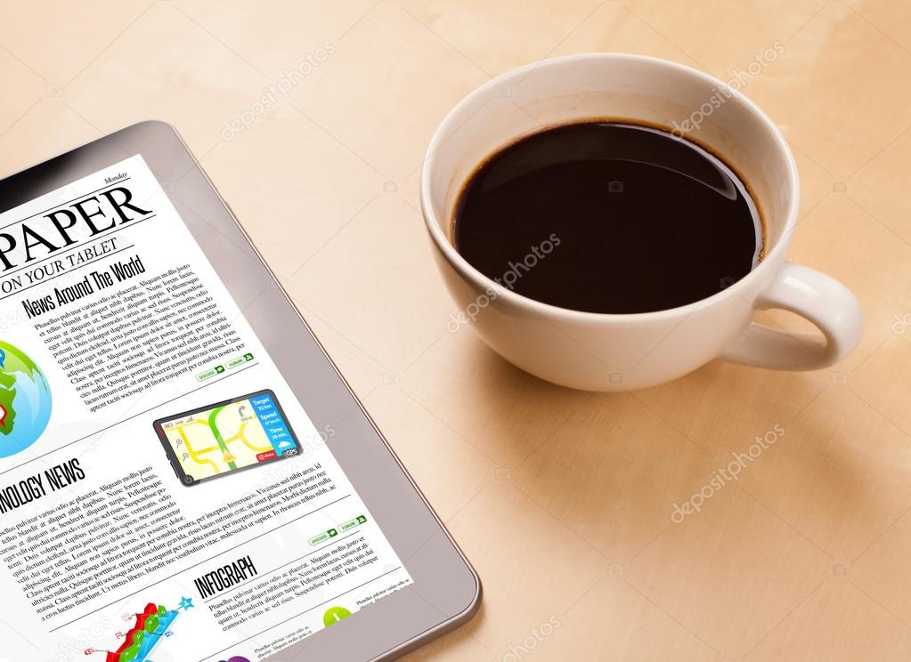 Tablet pc shows news on screen with a cup of coffee on a desk