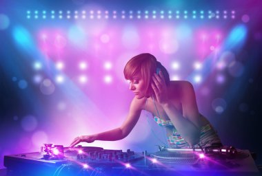 Disc jockey mixing music on turntables on stage with lights and  clipart