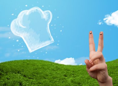 Mutlu gülen yüzlü parmaklar aşçı şapkasının resmine bakıyor.