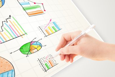 İşadamı kağıda renkli grafikler ve simgeler çiziyor
