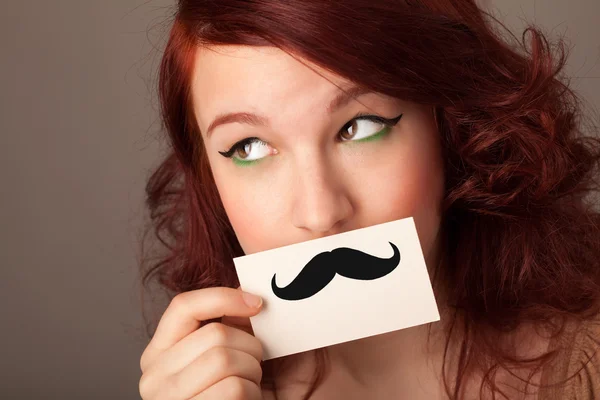 Happy cute girl holding paper with mustache drawing — Stock Photo, Image