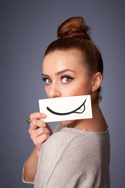 Hübsche junge Mädchen mit weißer Karte mit Lächeln Zeichnung — Stockfoto