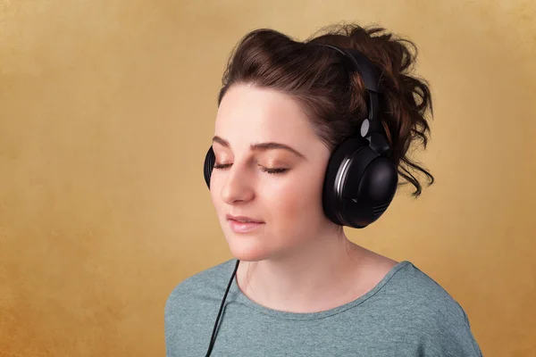Ung kvinne med hodetelefoner som lytter til musikk med kopiplass – stockfoto