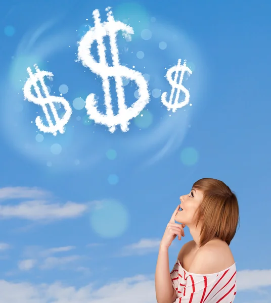 年轻的女孩指着美元符号在蓝蓝的天空上的云 — 图库照片