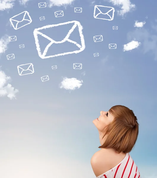 Young girl looking at mail symbol clouds on blue sky — Stock Photo, Image