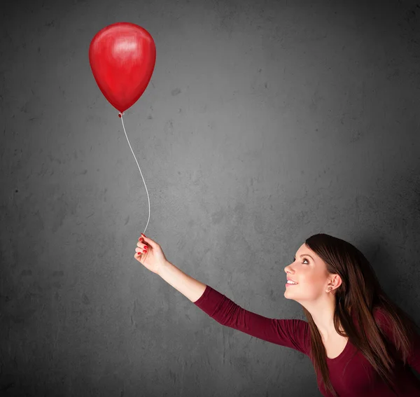 Mulher segurando um balão vermelho — Fotografia de Stock